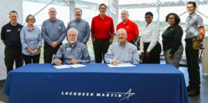 Lockheed employees and Chatt Tech faculty and staff gather at table for signing event