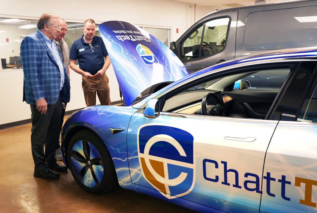 Three men look at EV engine at Chatt Tech