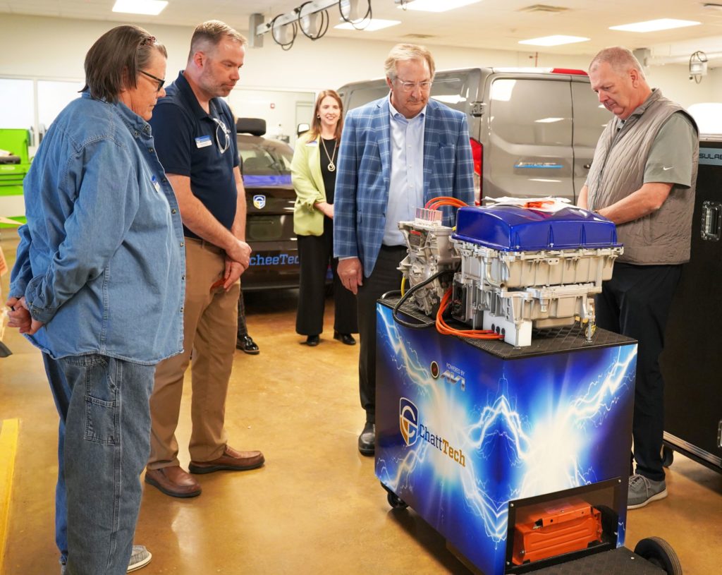 Group of five people representing Chatt Tech and Ed Voyles Automotive Group tour EV automotive area at Chatt Tech.